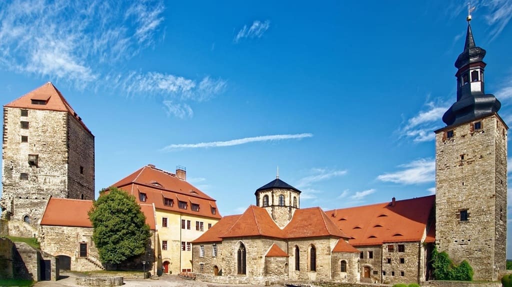 Blick auf die mittelalterliche Burg und Stiftskirche mit Türmen und roten Dächern in Sachsen-Anhalt