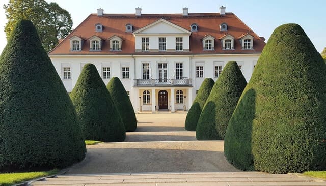 Barockes Schloss Wackerbarth in Sachsen mit symmetrisch geschnittenen Bäumen