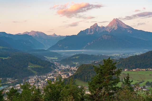 Blick auf Berchtesgaden im Morgenlicht mit dem markanten Watzmann-Massiv im Hintergrund.