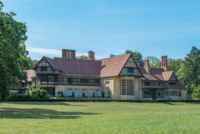Fachwerkschloss im englischen Tudorstil in weitläufiger Parkanlage.
