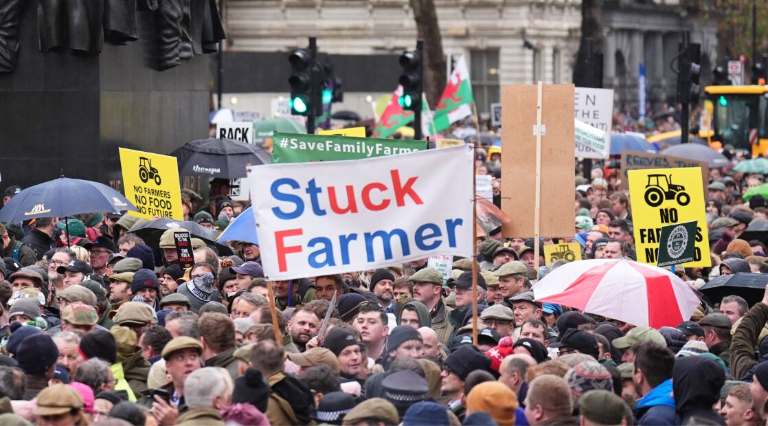 Crowd of farmers at a protest holding a Stuck Farmer banner, Save Family Farms and No Farmers No Food placards