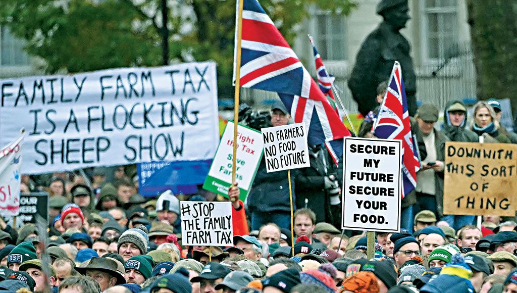 Crowd of protesters with Union flags and placards including Family Farm Tax is a Flocking Sheep Show and Stop the Family Farm Tax