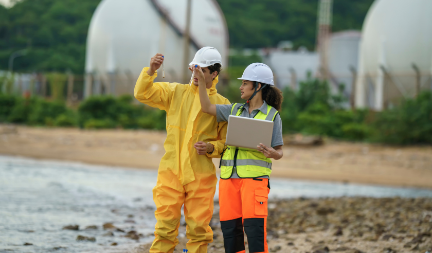 Environmental field scientists collecting samples at an industrial site.