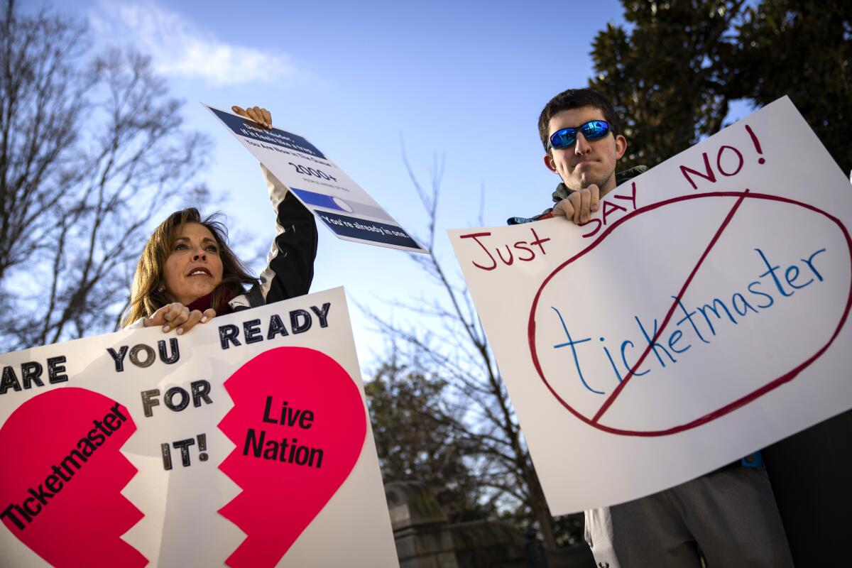 Two people hold signs, one reading "Just say no!" to Ticketmaster.