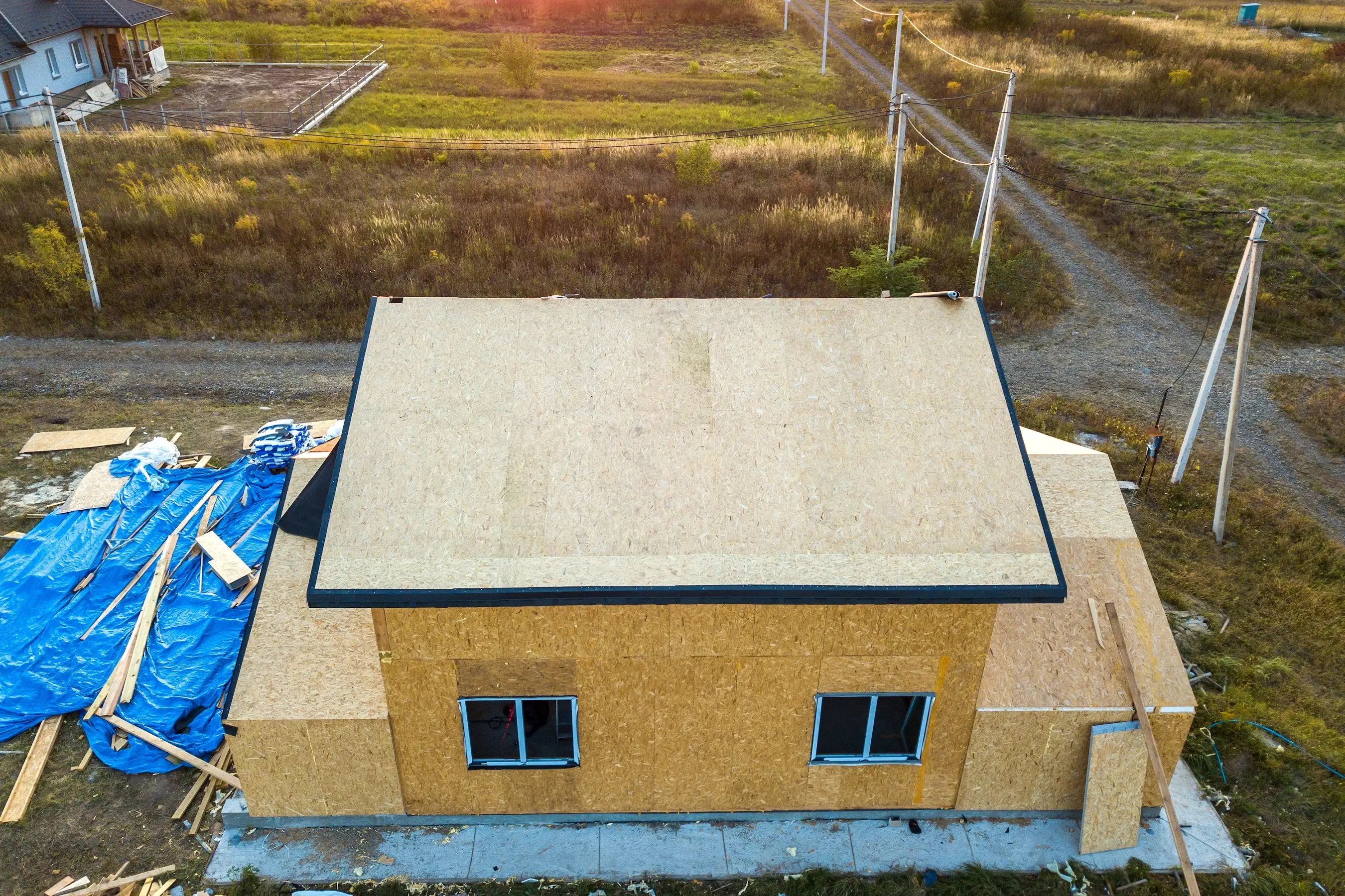 Accessory dwelling unit under construction with wood framing and roof sheathing on residential property