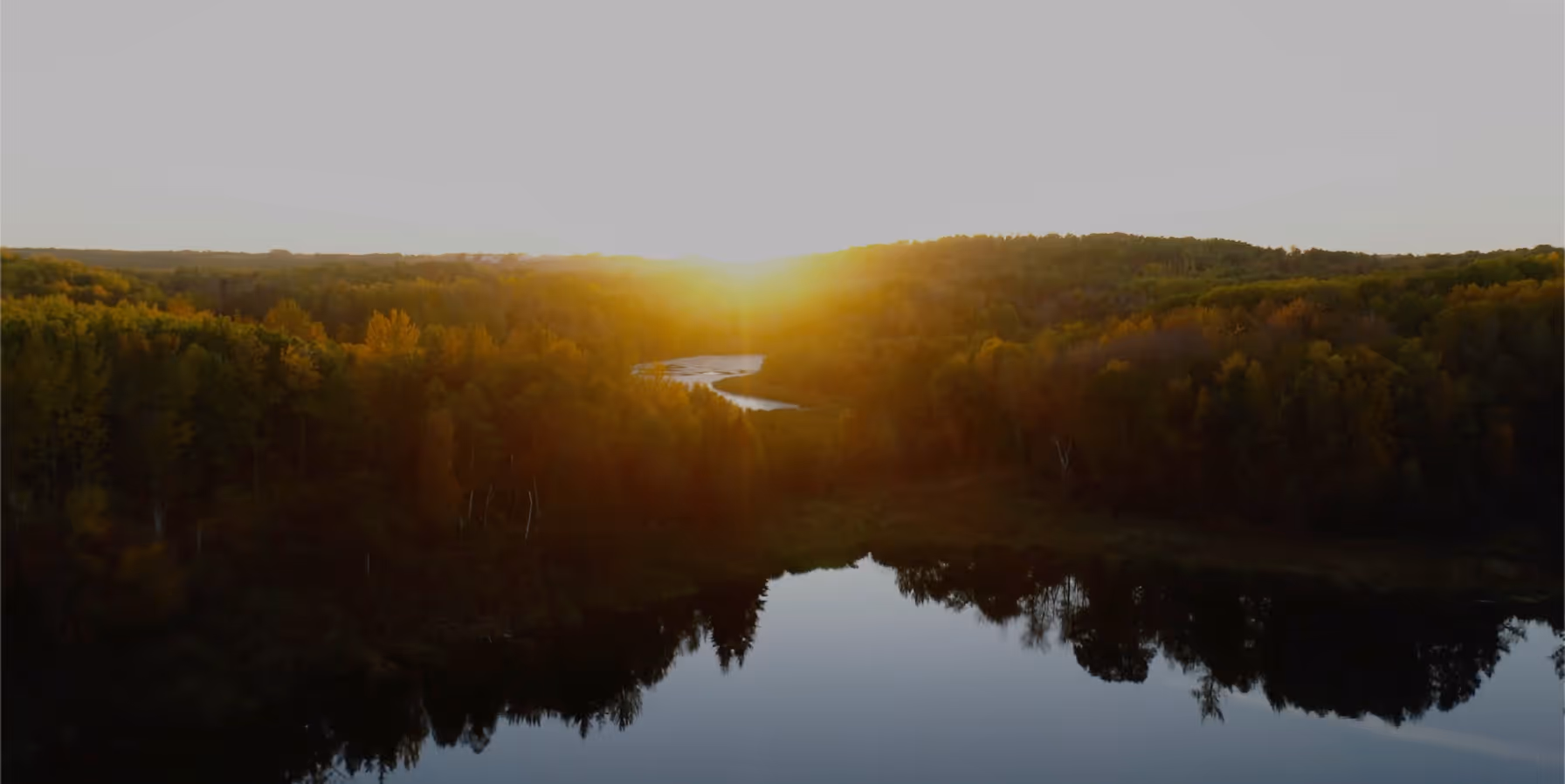 Sunset over a winding river and forest in Parkland County