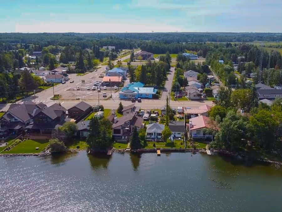 Aerial view of lakeside homes and a small-town main street in Lac Ste. Anne County, Alberta