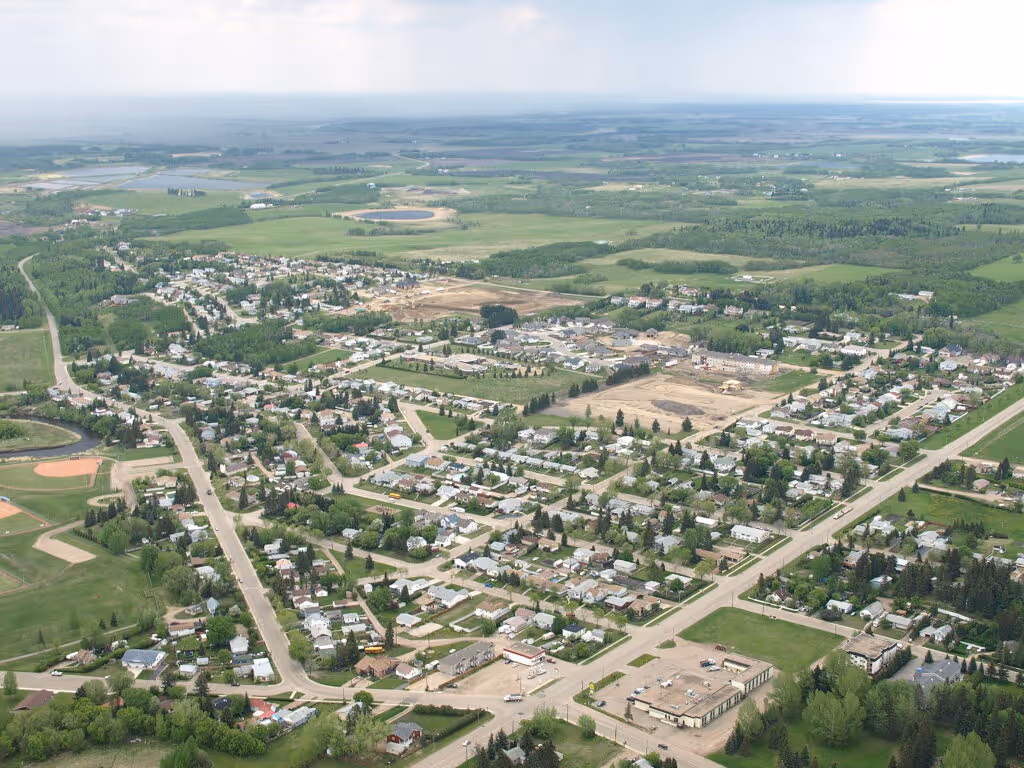 Aerial view of Ponoka with residential neighborhoods, civic buildings, and surrounding farmland.
