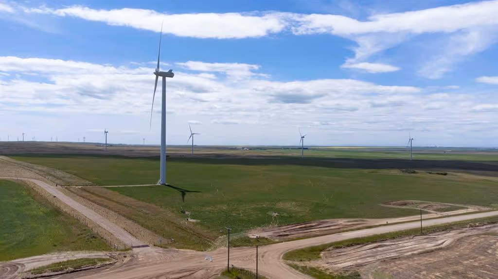 Wind turbines on open prairie in Vulcan County under a partly cloudy sky