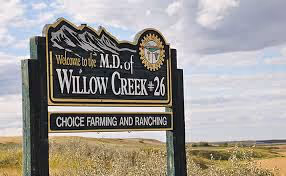 Welcome to M.D. of Willow Creek sign by prairie fields, Choice Farming and Ranching