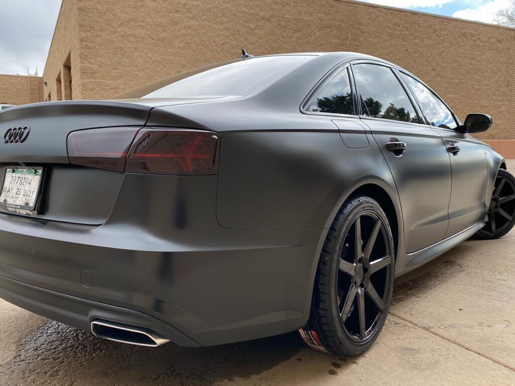 Audi A6 blacked out! Satin black vinyl wrap, gloss black chrome delete, tinted taillights and new custom wheels. Back View.