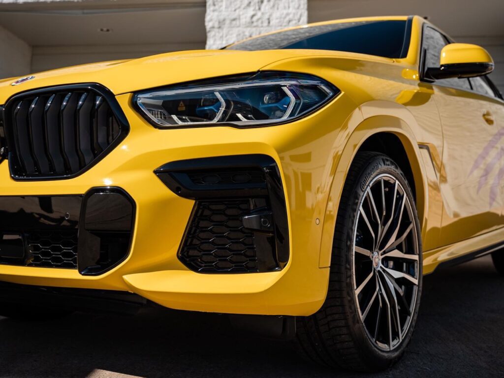 BMW X6 gloss yellow vinyl wrap topped off with two layers of ceramic coating plus ceramic window tint