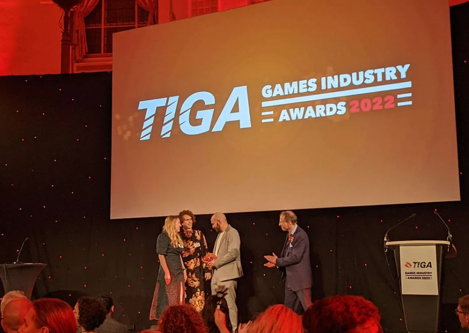 Three Roll7 representatives receive the TIGA award on stage