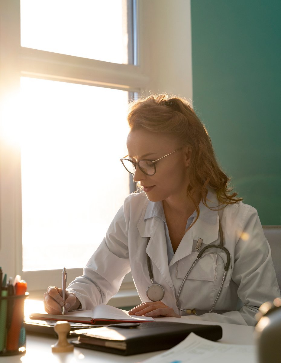 Healthcare professional writing notes at desk in clinical setting - respiratory therapy education and workforce development