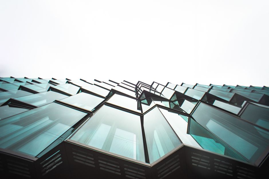 Low angle view of a modern building's glass facade, showcasing architectural design.