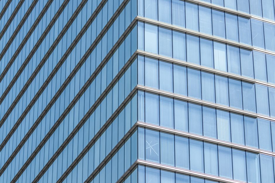 Close-up of a modern glass building facade showcasing geometric lines and reflections.