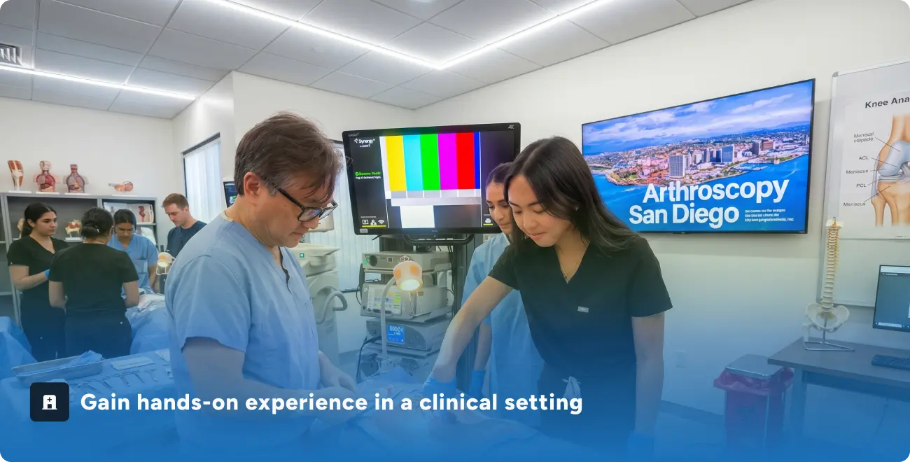 Medical professionals in scrubs working together in a clinical training room with screens and anatomy models.