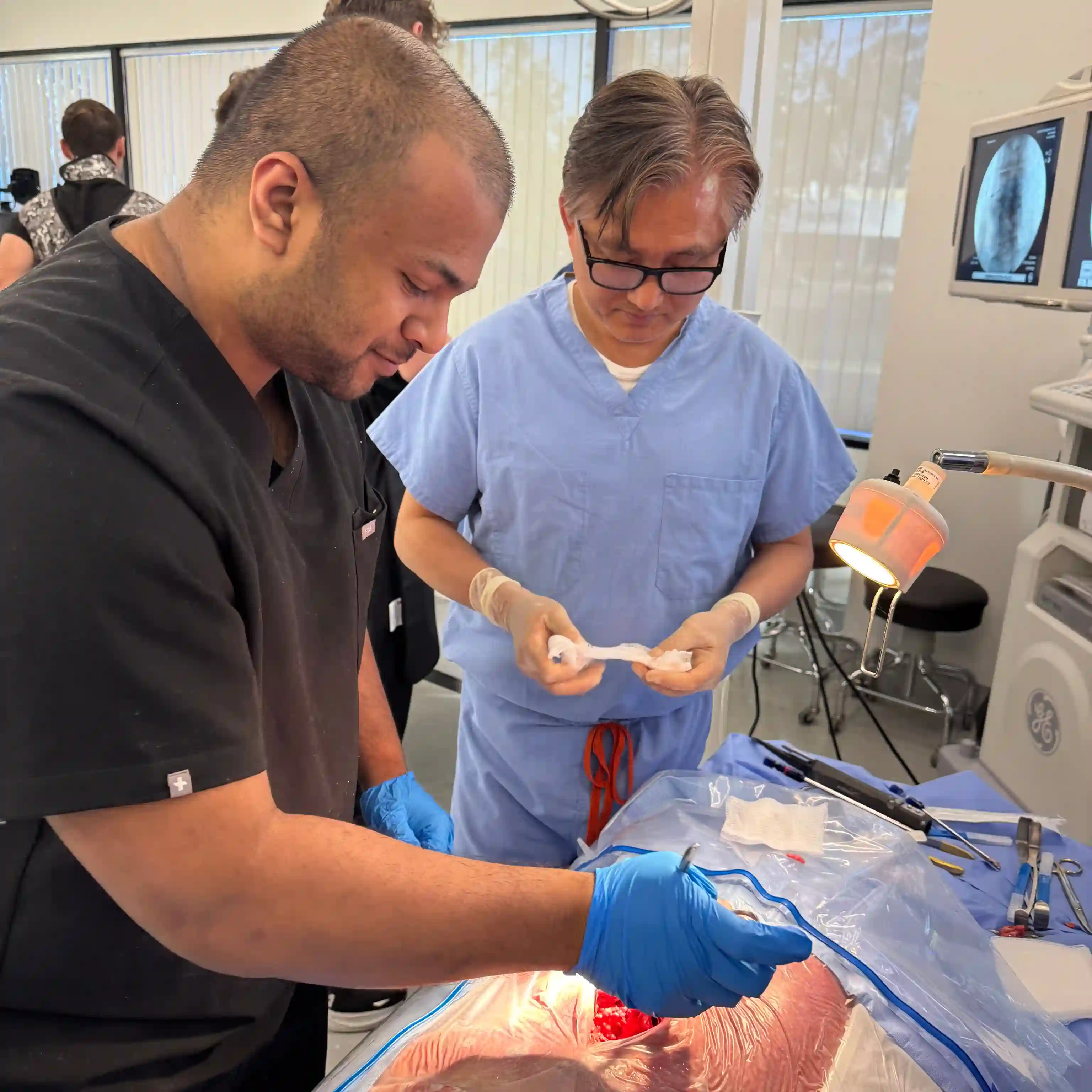 Dr. Yoo performing a surgical procedure under bright lamp in clinical setting.