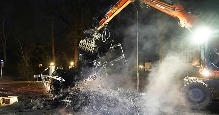 Kraan van Van der Lee verwijdert smeulende resten van een autowrak na een calamiteit