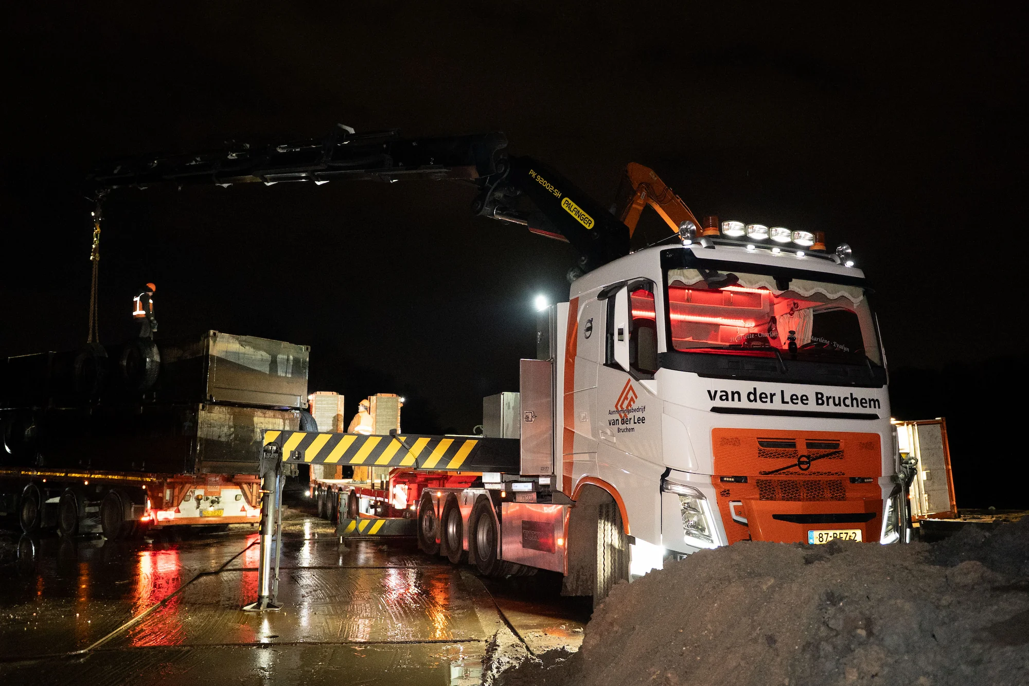 Autolaadkraan van Van der Lee met rode verlichting tijdens het transport van pontons