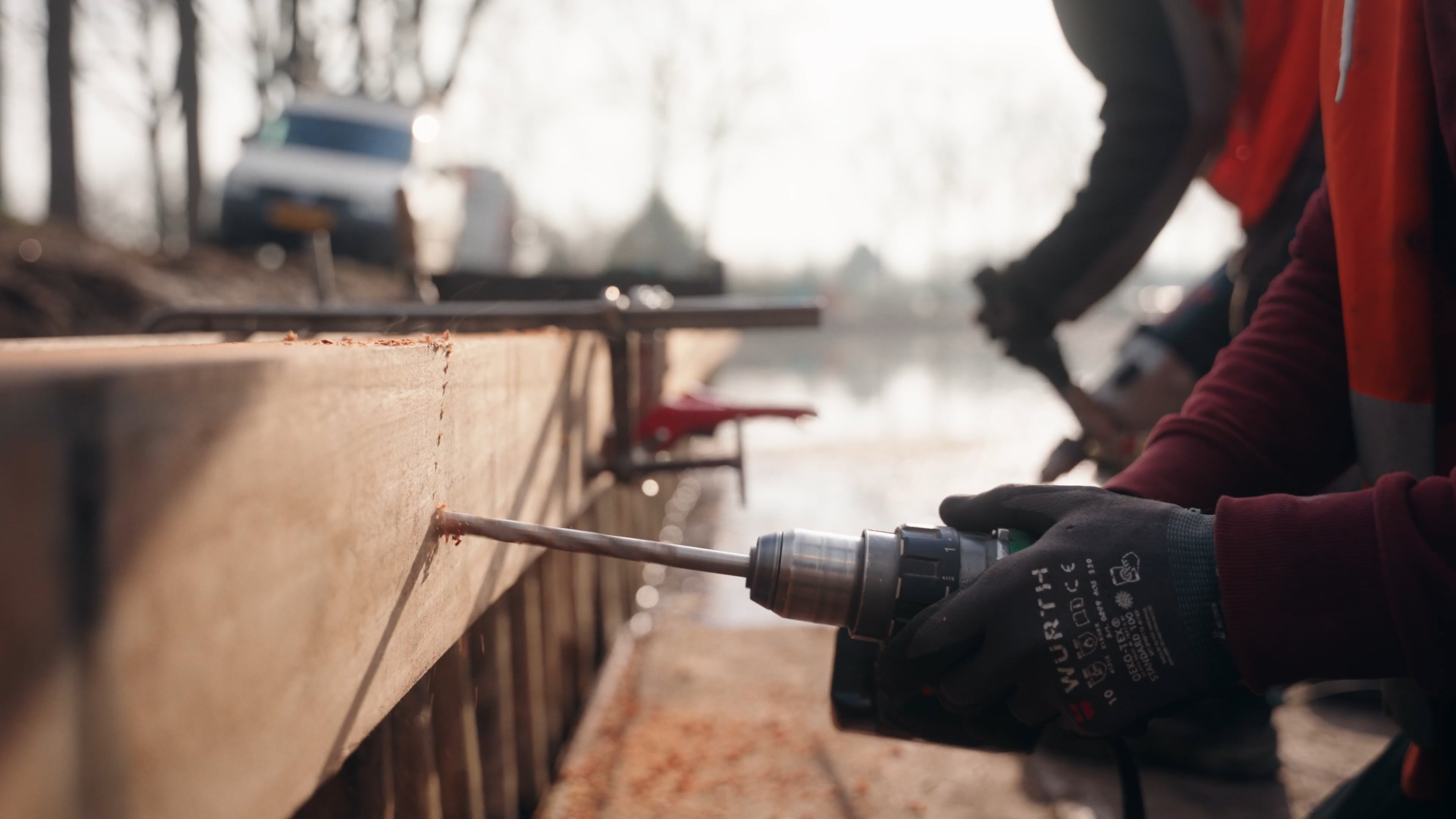 Medewerker van Van der Lee plaatst houten oeverdelen tijdens waterbouw werkzaamheden