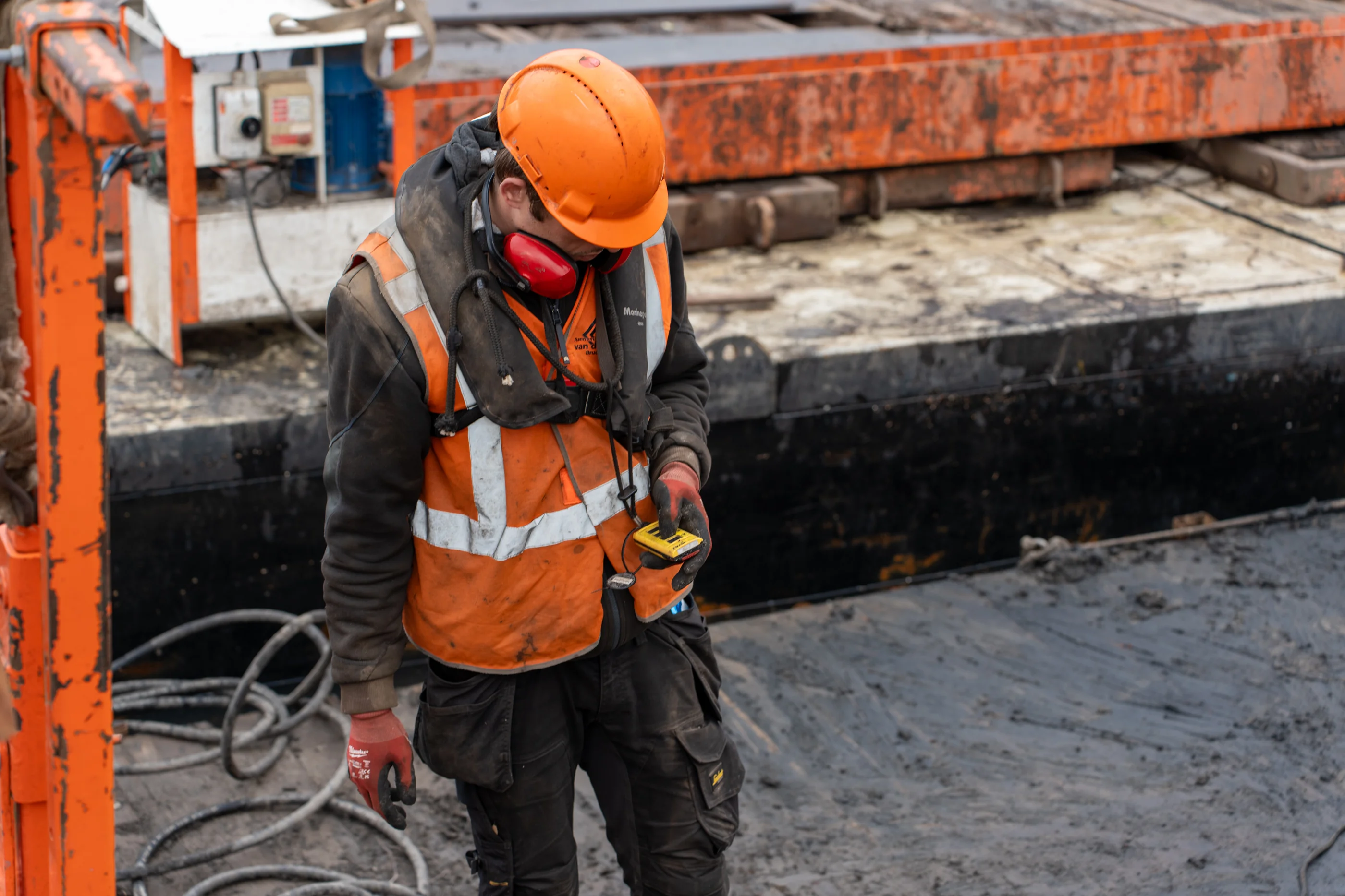 Medewerker controleert materieel op ponton tijdens waterbouw werkzaamheden
