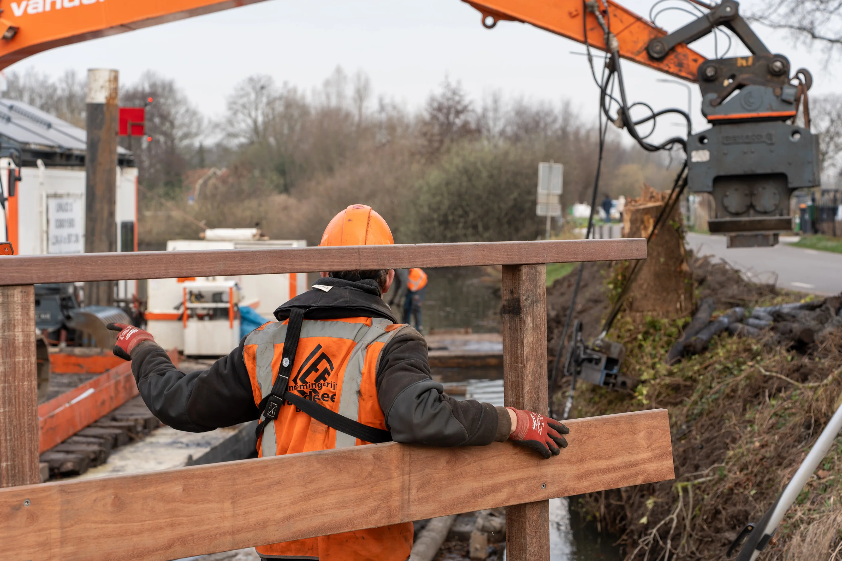 Medewerker van Van der Lee plaatst houten oeverdelen tijdens waterbouw werkzaamheden