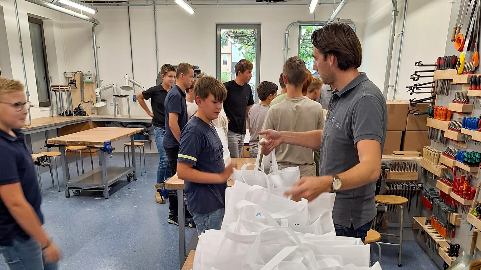 Van der Lee Bruchem deelt goodybags uit aan bouwleerlingen in het technieklokaal van Gomarus Scholengemeenschap.