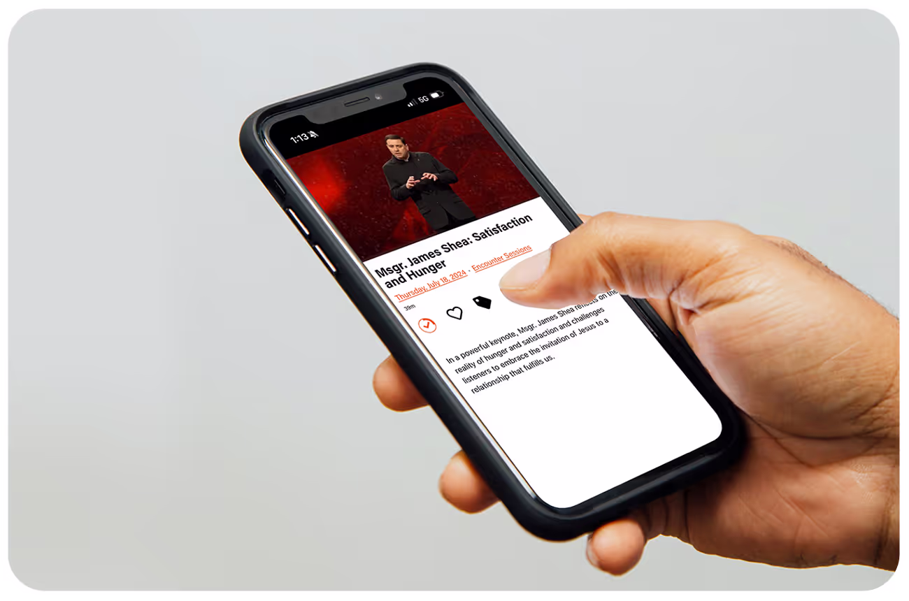 Person’s hand holding a phone watching a talk by Msgr. Shea using an app built on the Annunciate platform
