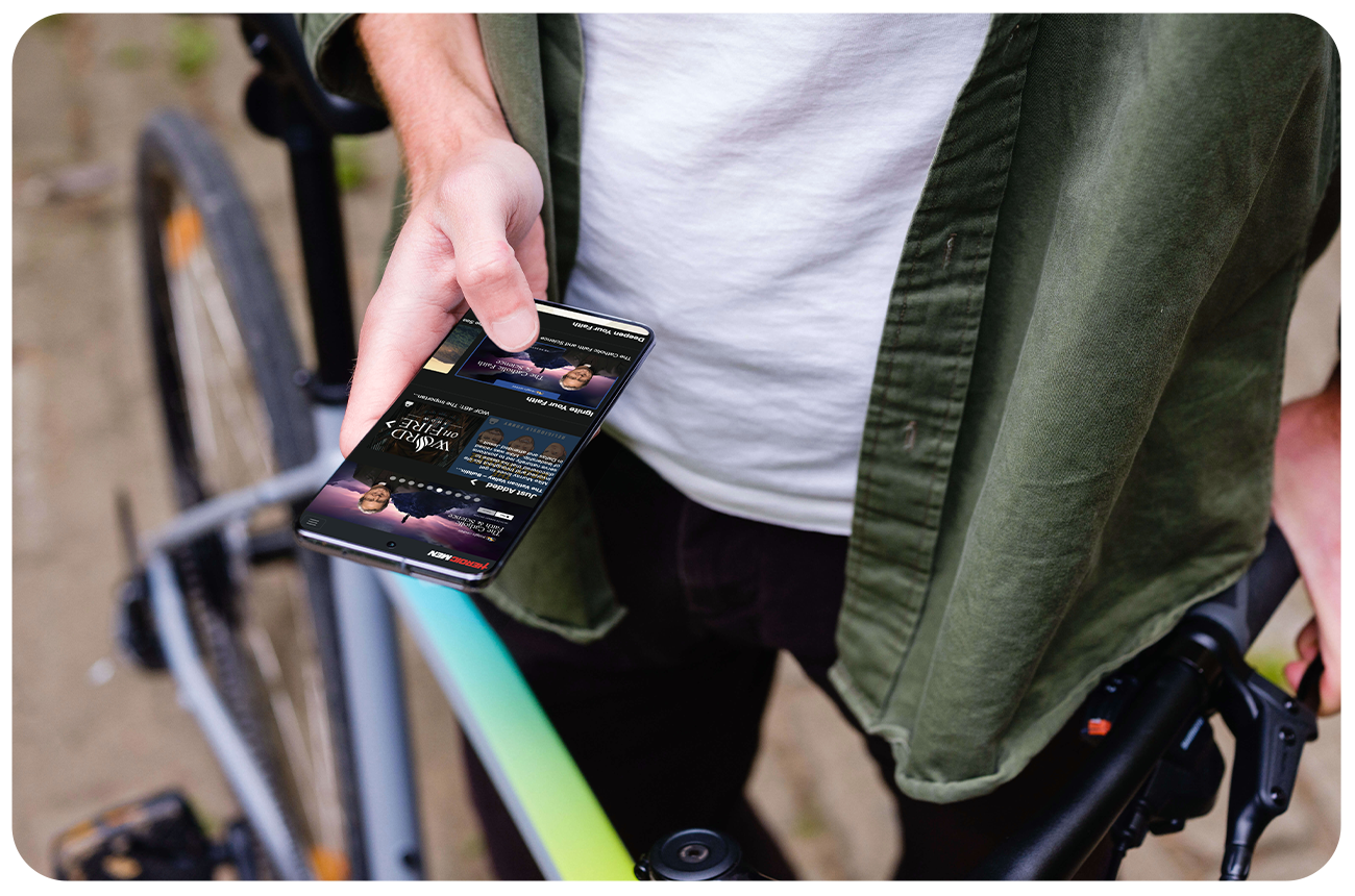 Man standing with a bike holding a smartphone