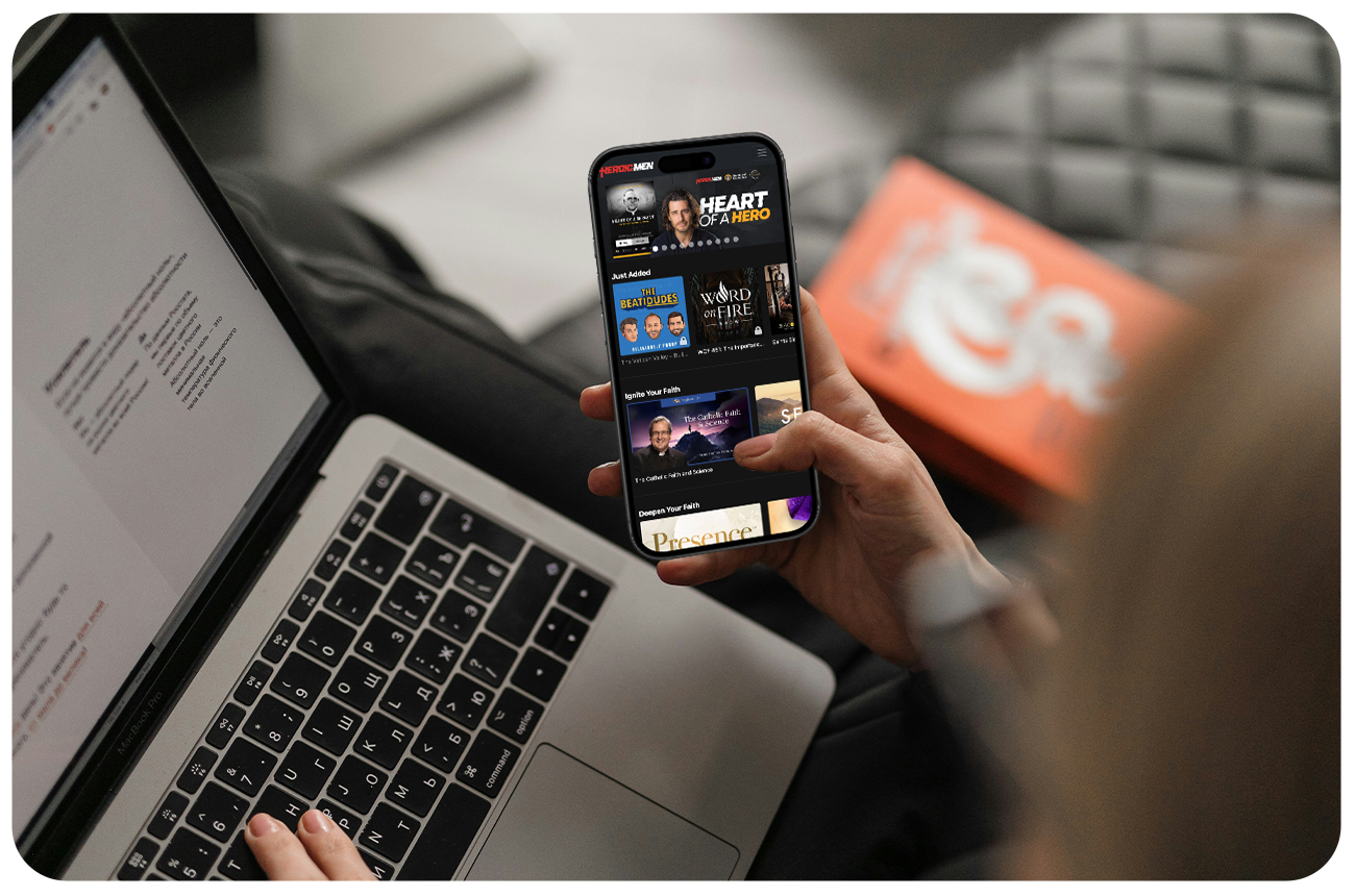 Woman scrolling on an app on her phone with a laptop on her lap