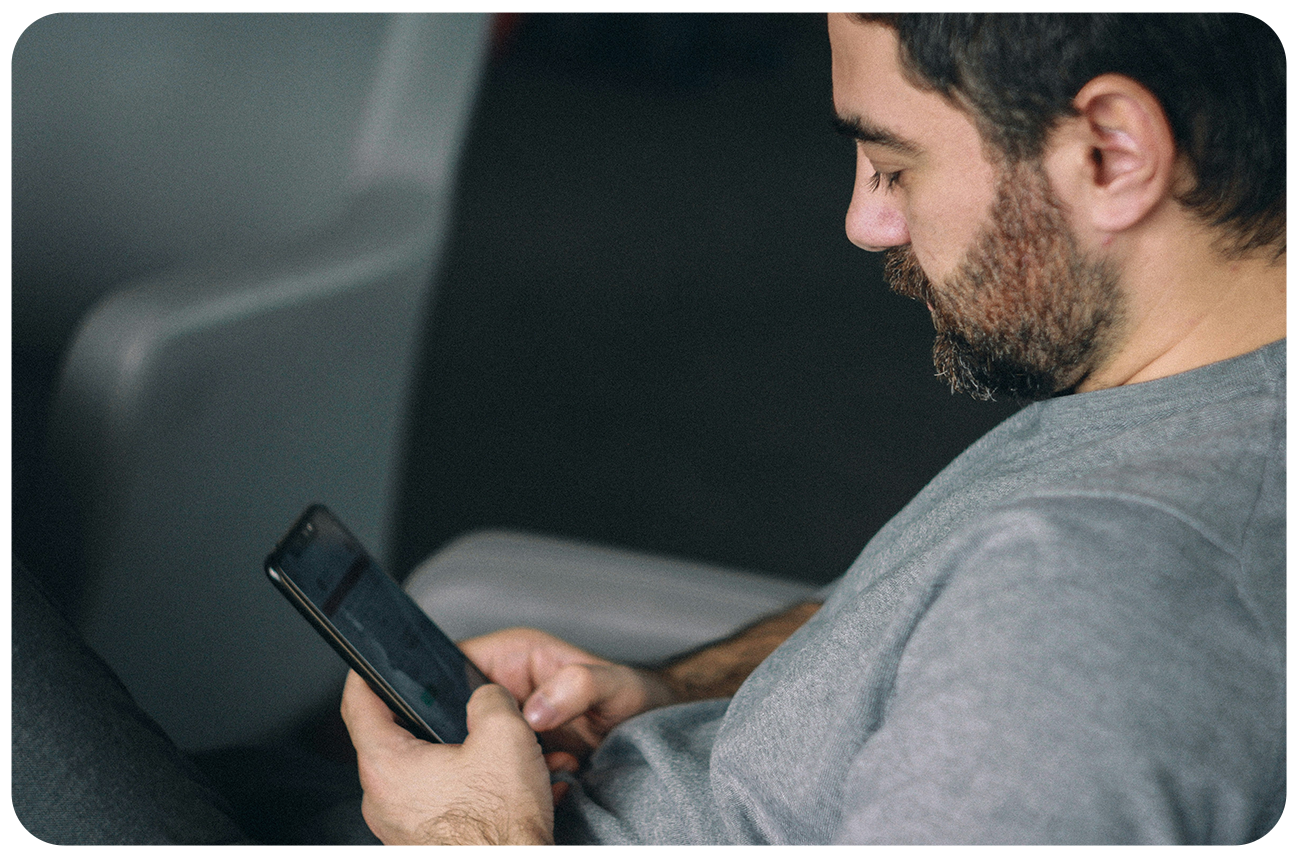 A man holding his phone and looking at the screen