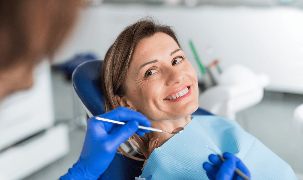 A woman in the dentist chair smiles while getting a dental checkup at the best dentist in Campbell, CA