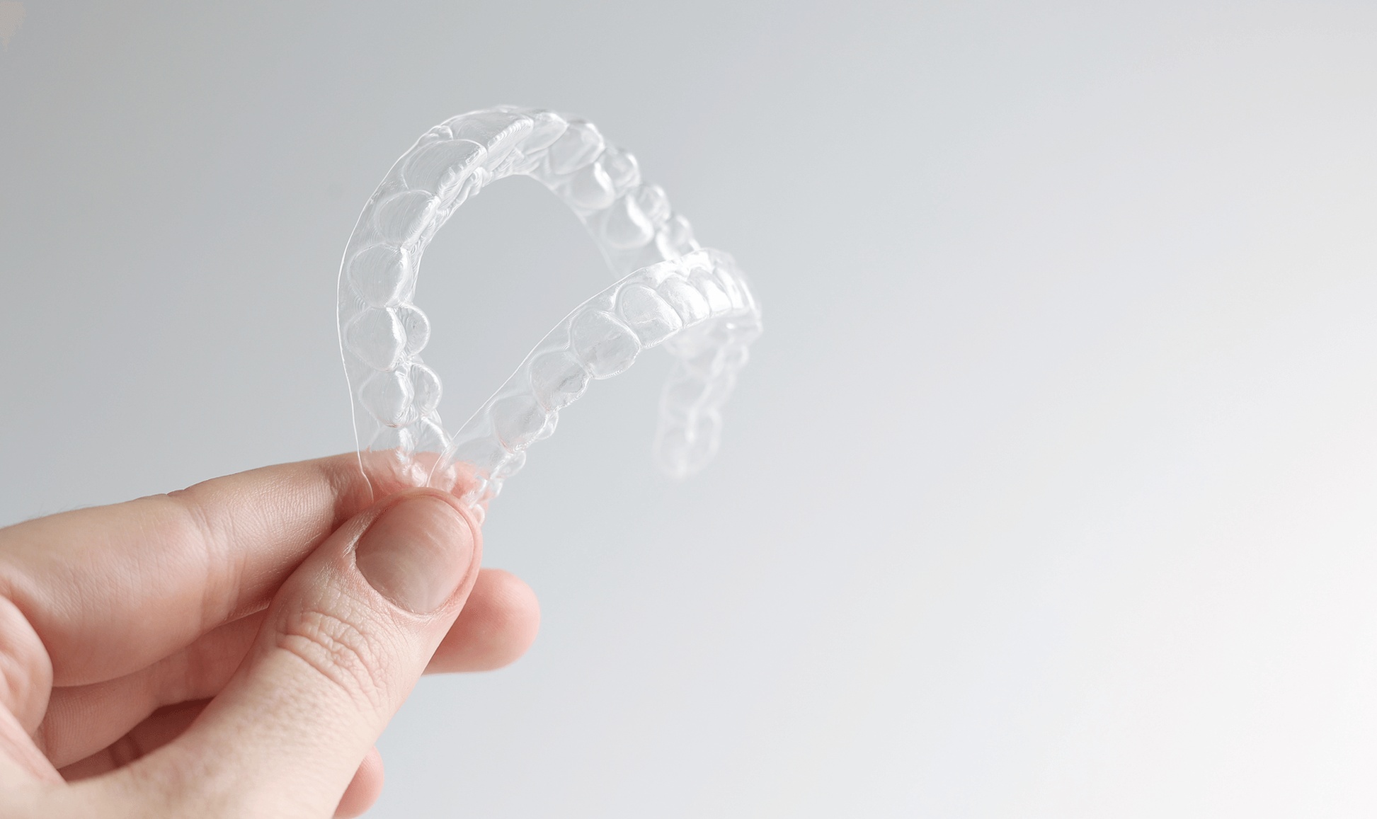 Clear Invisalign aligner held in hand, representing discreet orthodontic treatment from the best dentist for Invisalign in Campbell, CA, to straighten teeth comfortably and effectively.
