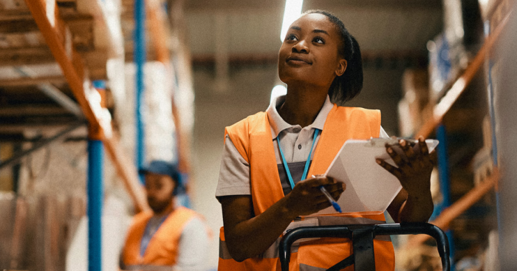 a woman in a warehouse with a clipboard