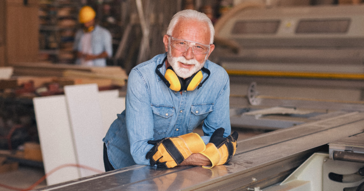 A man in protective gear leans against machinery.