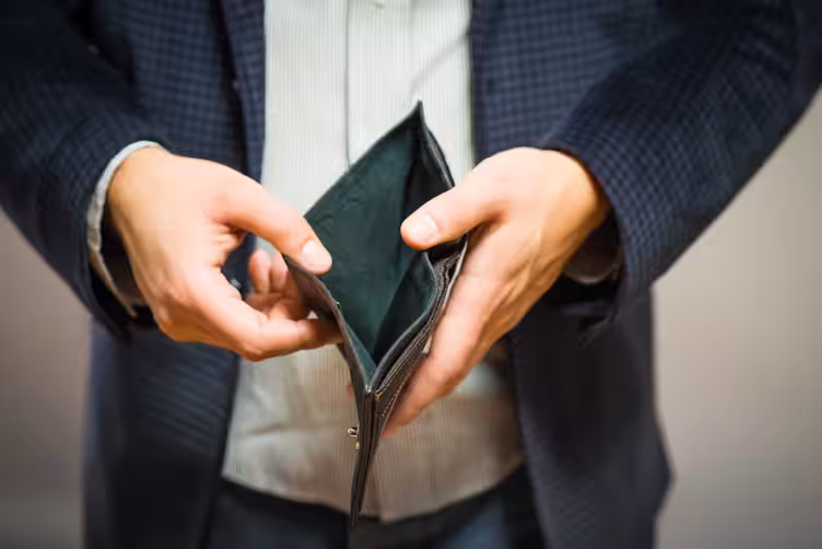 Hands holding an empty wallet, symbolizing the financial challenges and lean resources of bootstrapping a startup or small business.