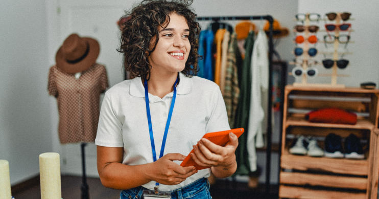 A woman with a badge and an ipad smiles