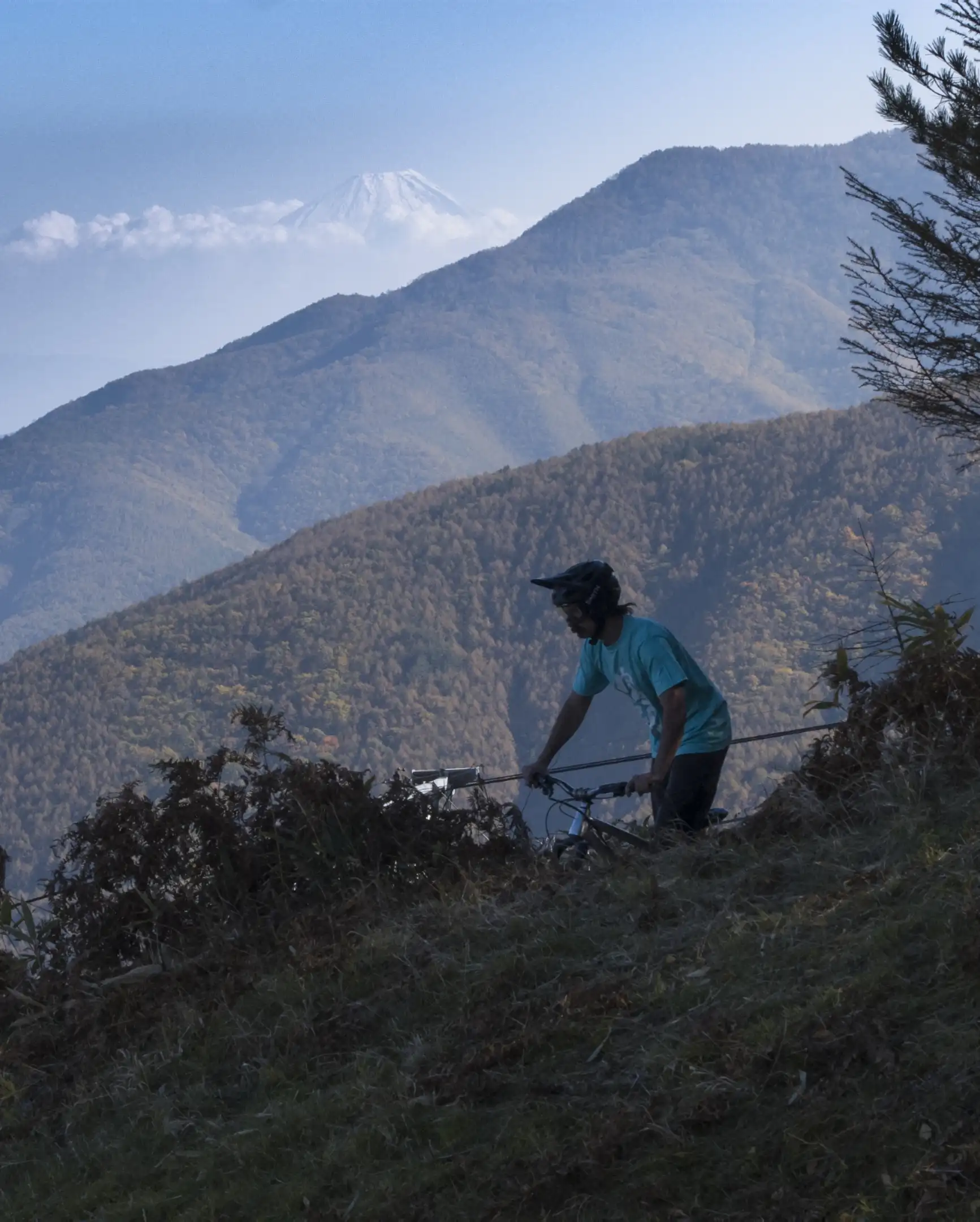 A mountain bike rider about to drop in with Mtn Fuji in the distance