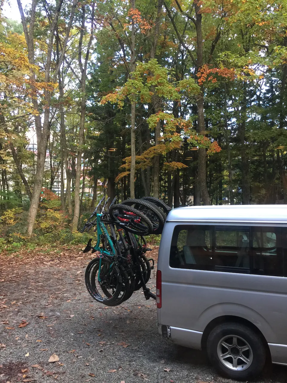 A van and hitch loaded with mountain bikes.