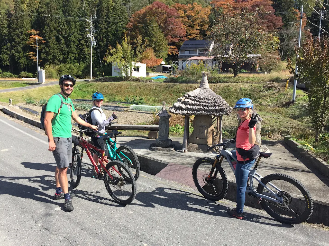 Three riders wait by a shrine in rural Japan.