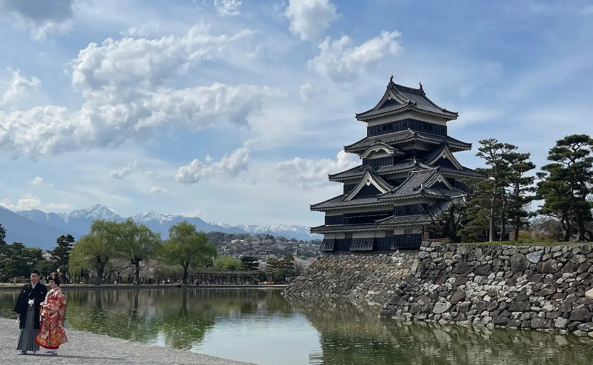Matsumoto Castle with a man and a woman in traditional Japanese dress.