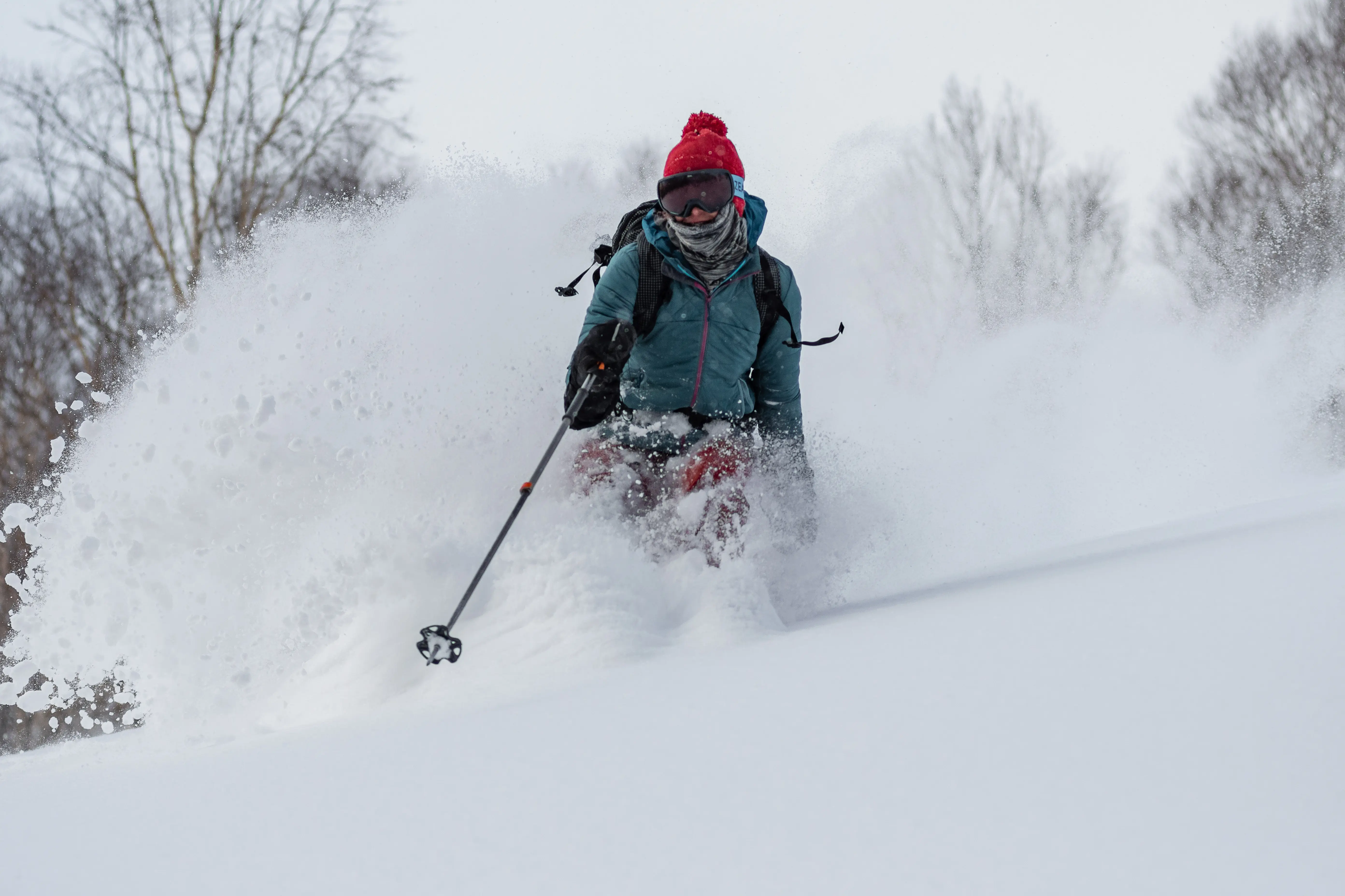Cold smoke, a skier makes a rooster tails in super fine powder, Japan.