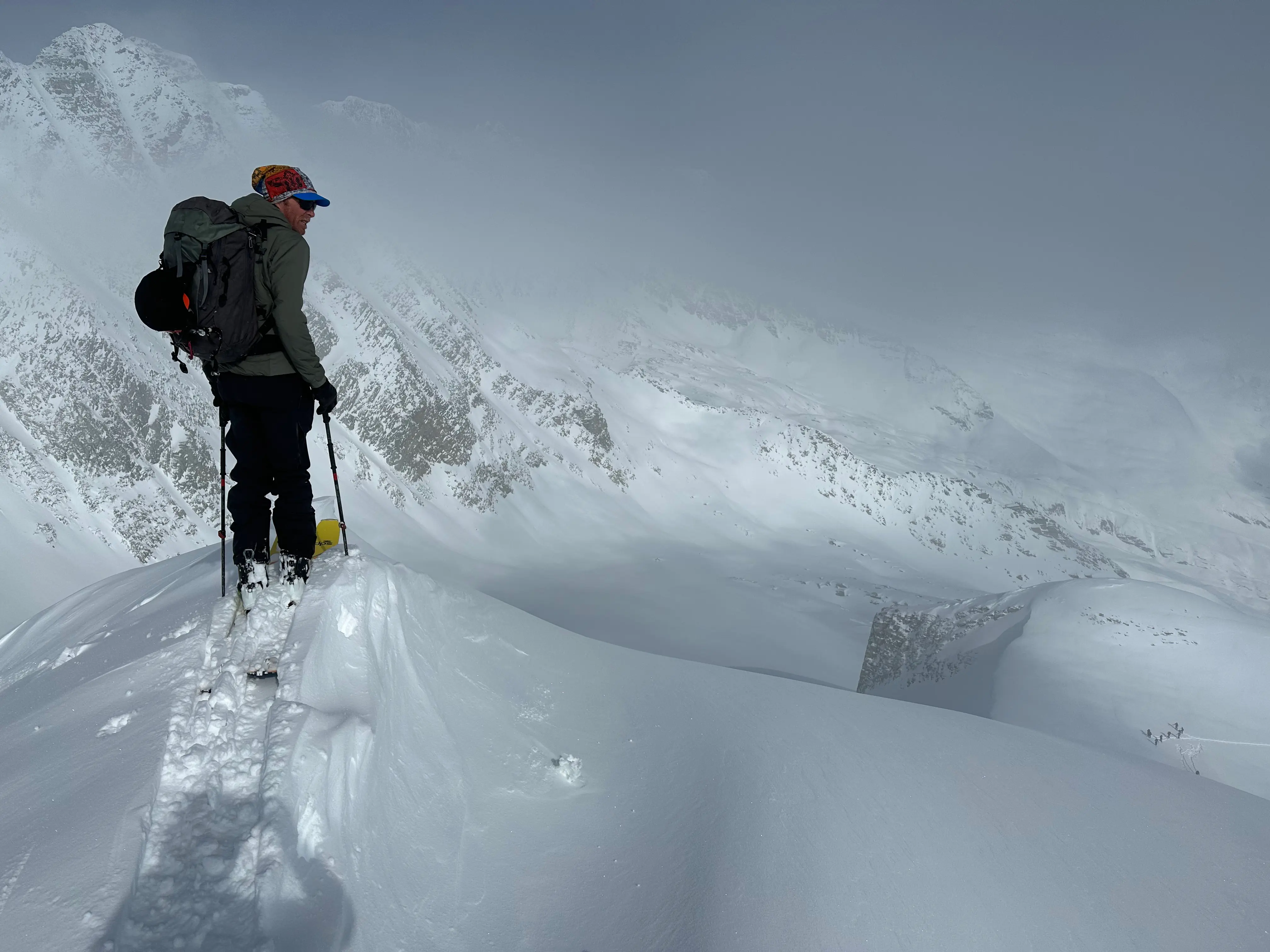 Backcountry skier on snowy summit, Rogers Pass.