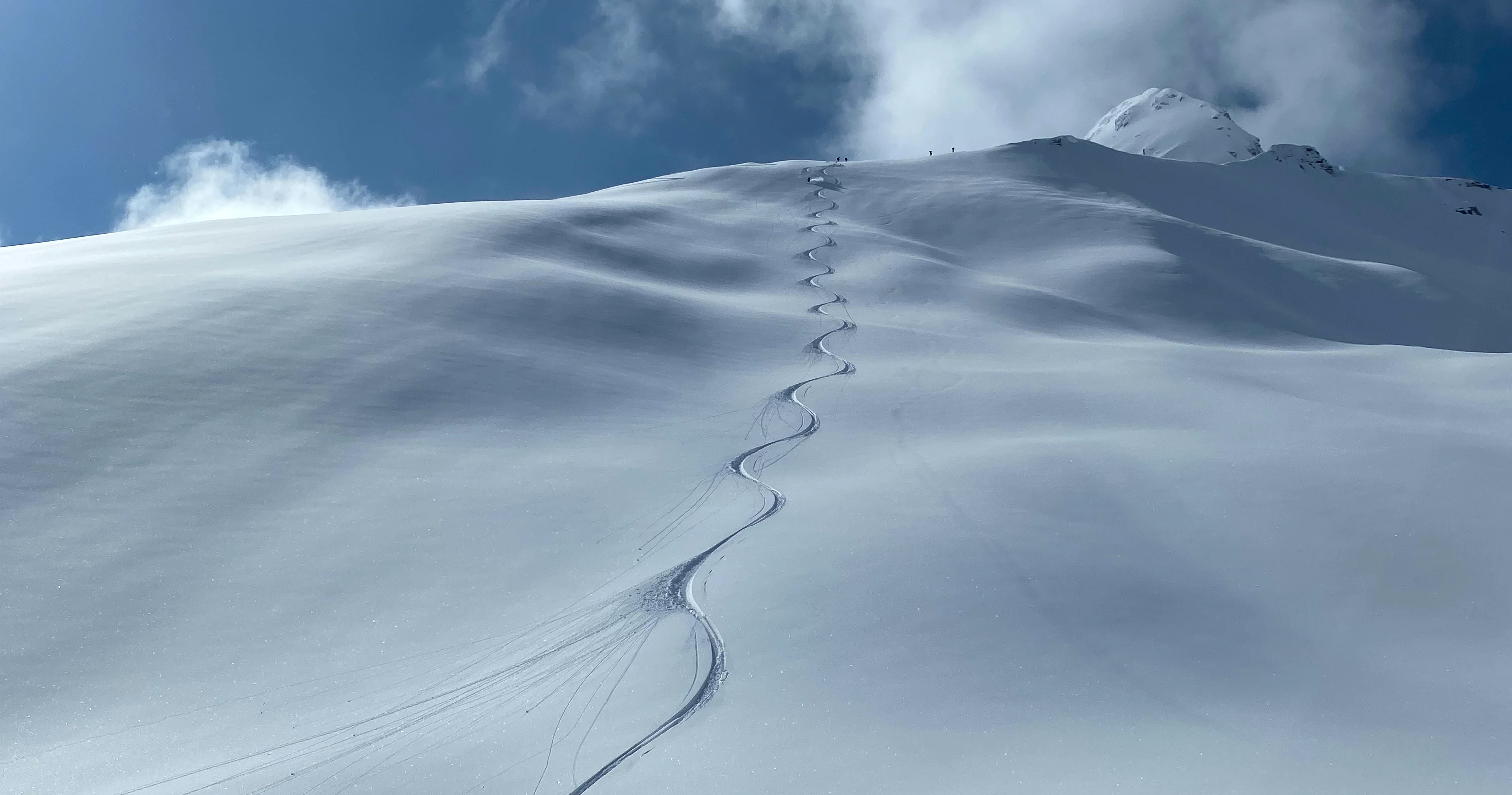 Single ski track down a large alpine face