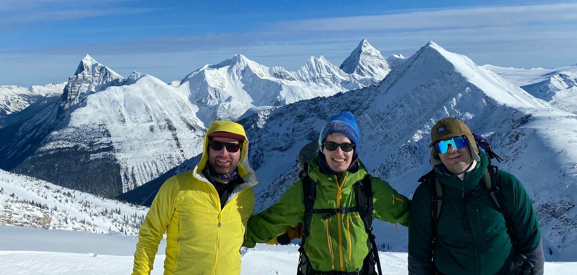 Three backcountry skiers friends high in the Selkirks