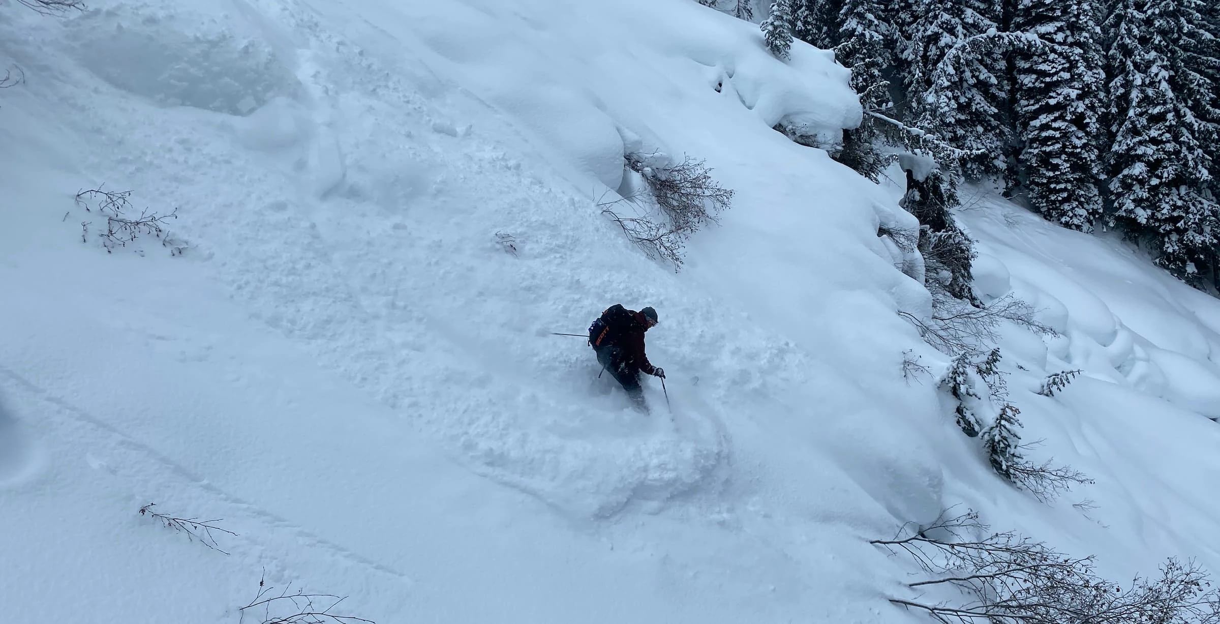A skier getting deep in an avalanche path