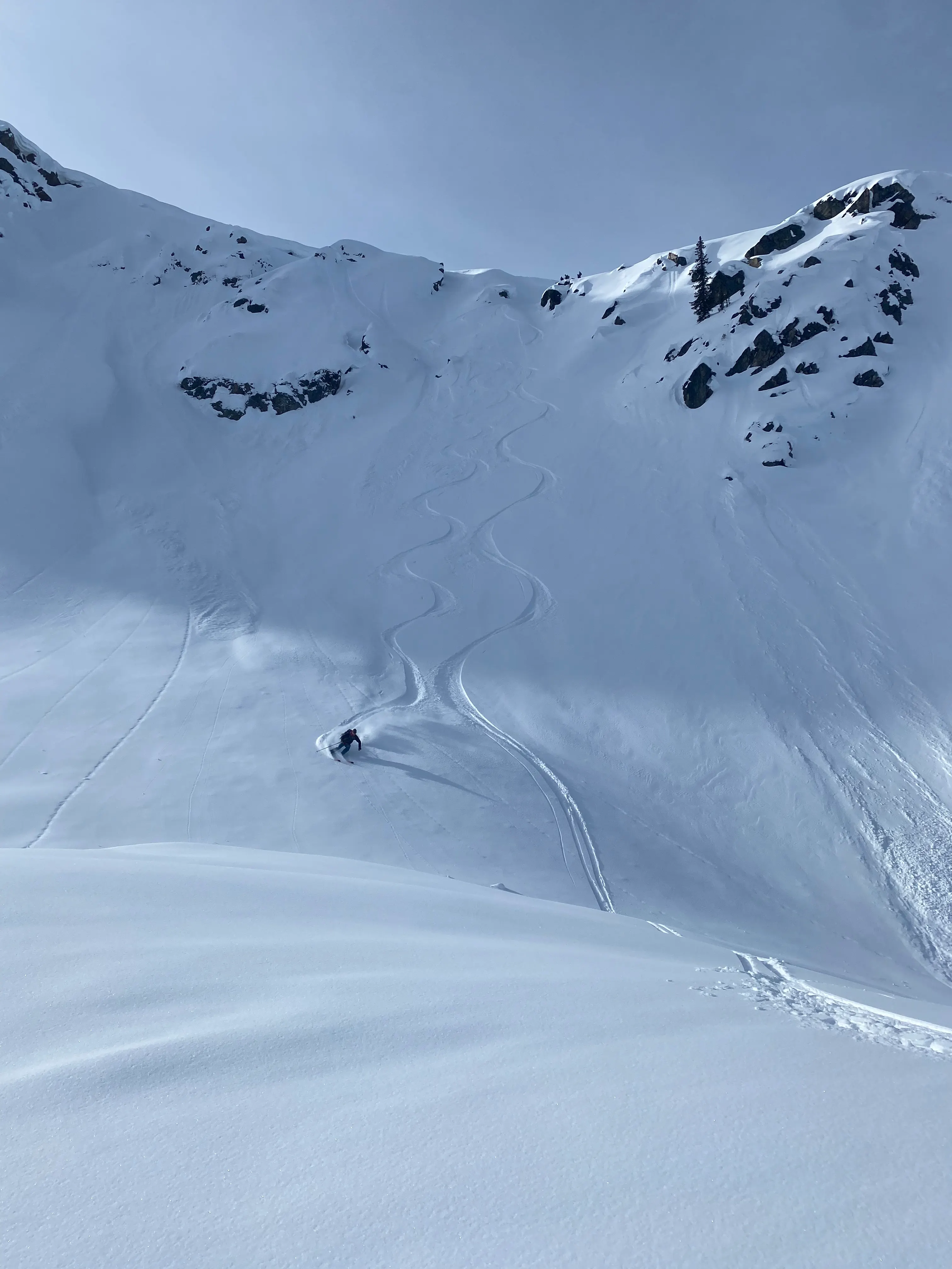 A backcountry skier descending a steep alpine line