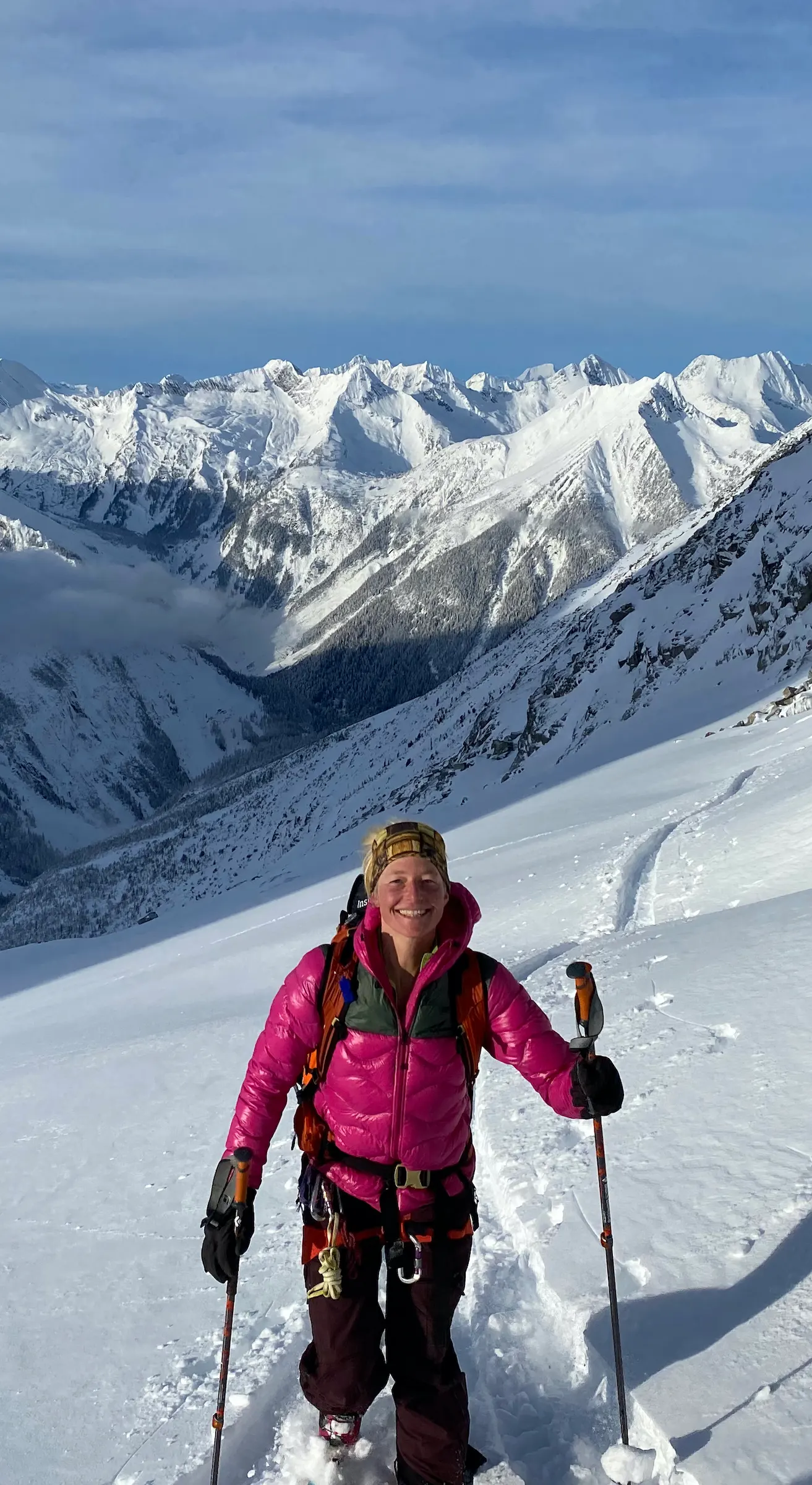 A woman skinning confidently, deep valley in background