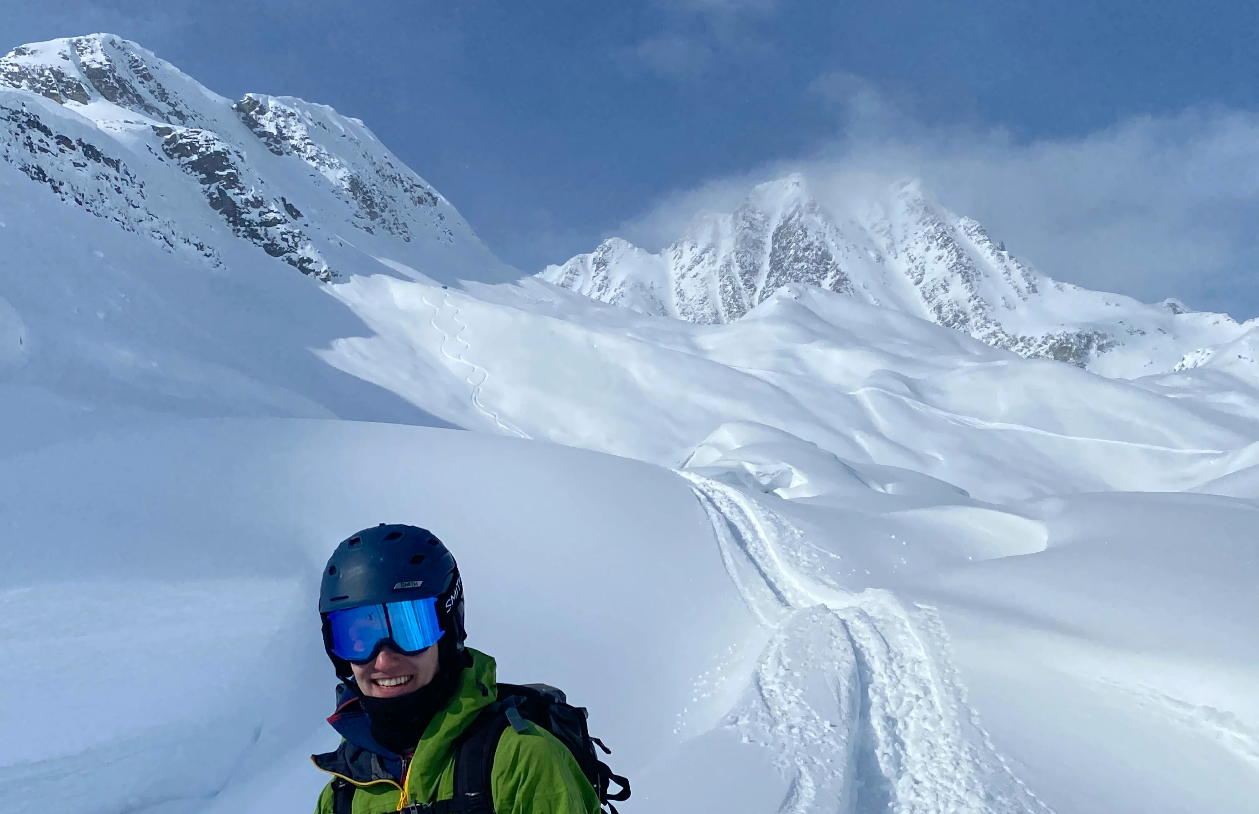 Backcountry skier in foreground, with his line in the background, Rogers Pass. 